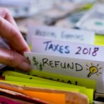 Tax files and tax refund files in a filing cabinet with woman going through tax records